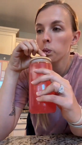 Video frame of a customer taking a sip of a pink Tavo LiquidCalm liquid calm drink.
